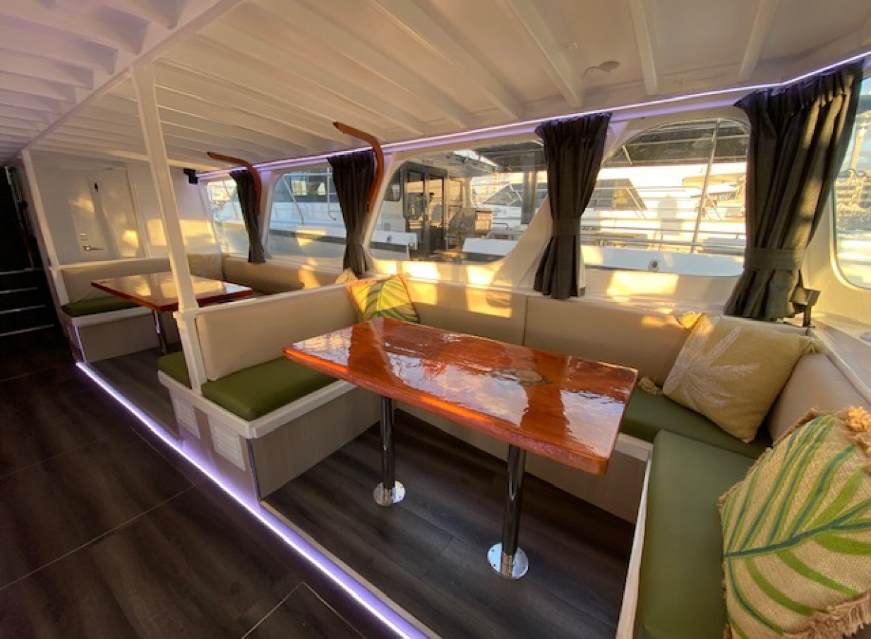 Stylish dining lounge with booth seating on an Ocean Groove Cruises charter boat in Auckland.