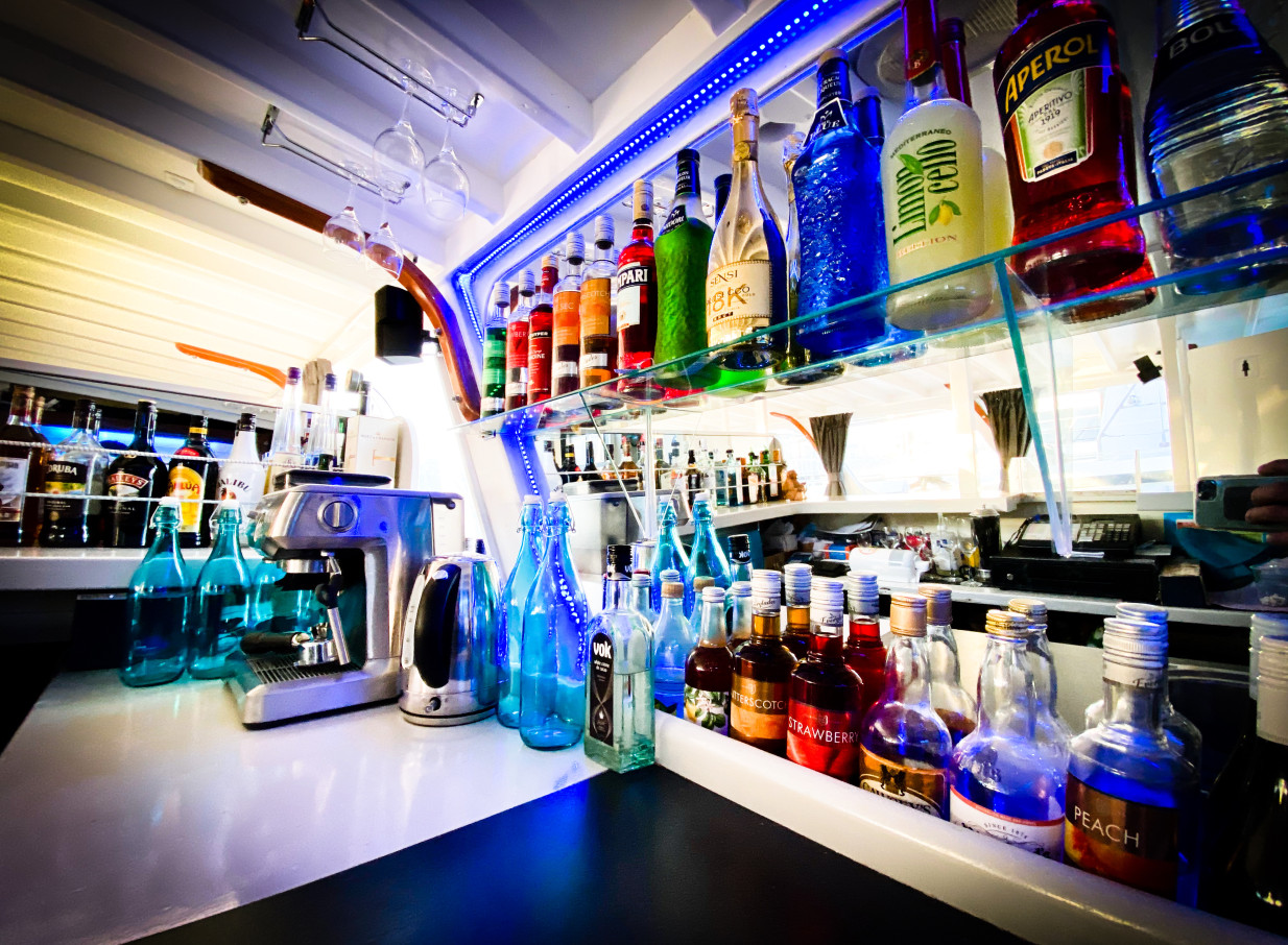 A modern, illuminated bar area on the Ocean Groove Cruises party boat in Auckland.