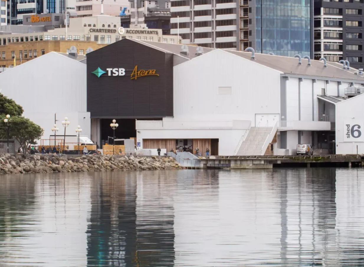 The TSB Arena, a Wellington waterfront venue, features a modern, wharf-shed inspired design with dark central and white gabled sections.