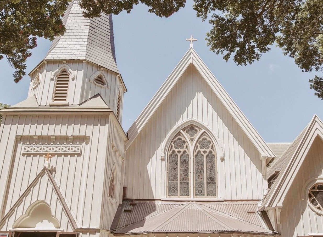Exterior view of Old St Paul's in Wellington, a stunning timber Gothic Revival church with a steeple and stained-glass windows.