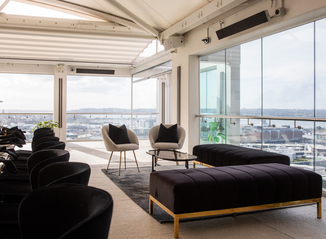 Rydges Auckland's modern rooftop lounge features a retractable roof, glass surrounds, and panoramic city views.