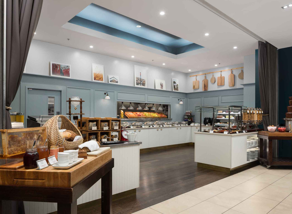 A contemporary breakfast buffet area at Rydges Auckland features fresh produce and natural textures.