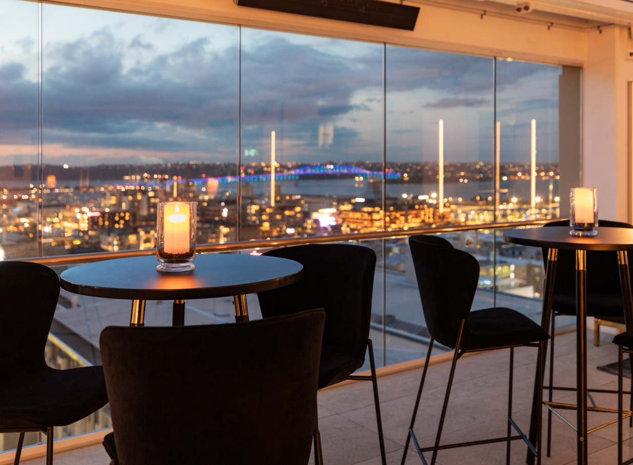 Enjoy the luminous rooftop bar at Rydges Auckland, offering luxurious panoramic views of the city and Harbour Bridge.