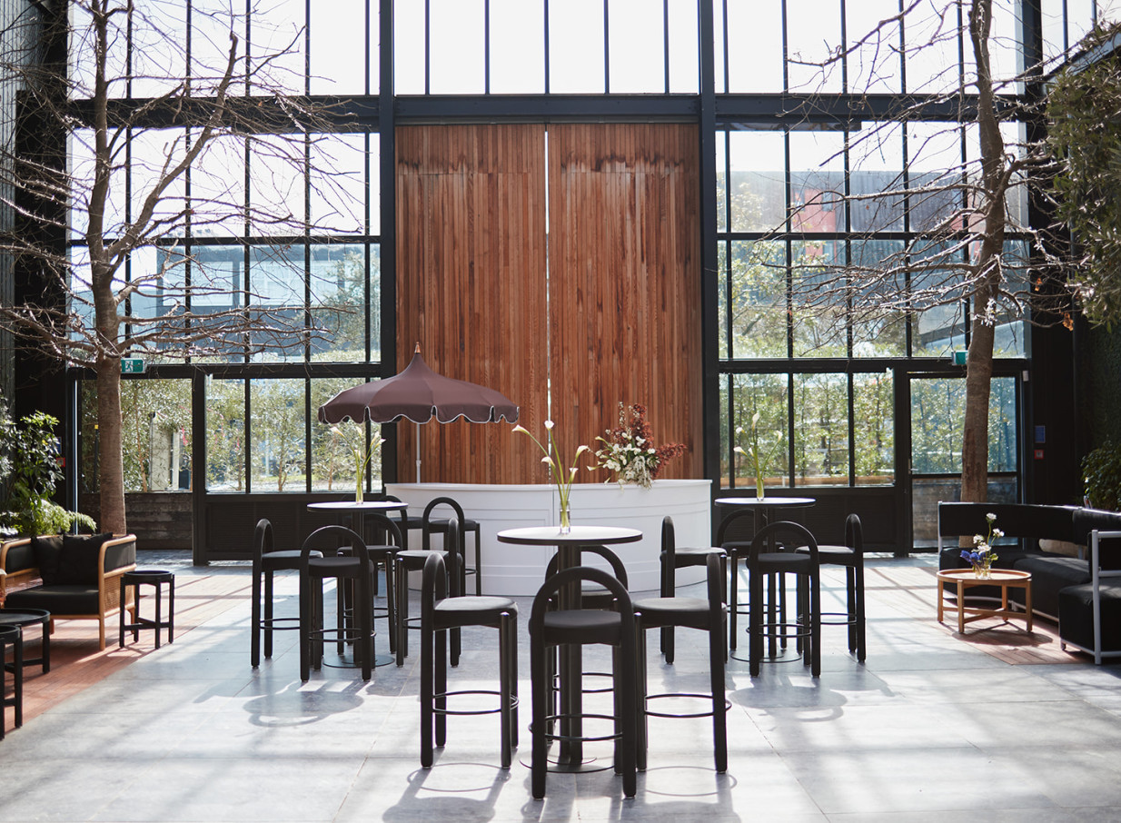 Glasshouse Morningside, Auckland's industrial-chic event space, set for a cocktail reception amidst distinctive glass walls.