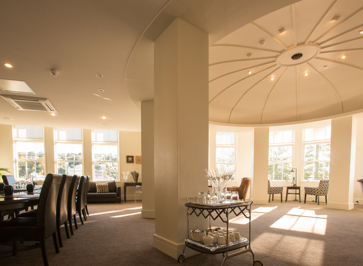 An elegant Art Deco event space at The Dome, Napier, featuring a grand domed ceiling, bright windows, and a dining setup.