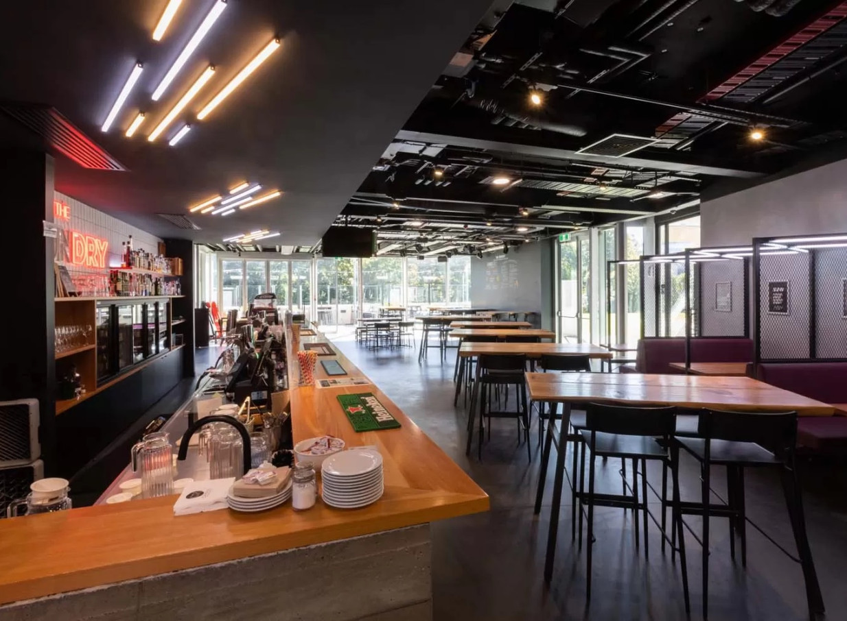 The Foundry, a modern industrial-chic bar and dining space at Haere-Roa in Christchurch, with exposed ceilings and large windows.