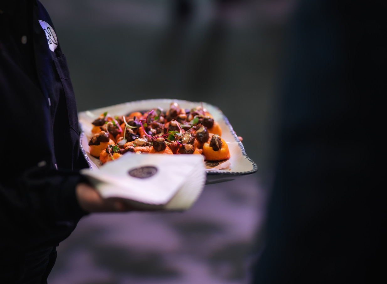 A server presents elegant appetizers at Haere-roa, a modern, architecturally designed event venue in Christchurch.
