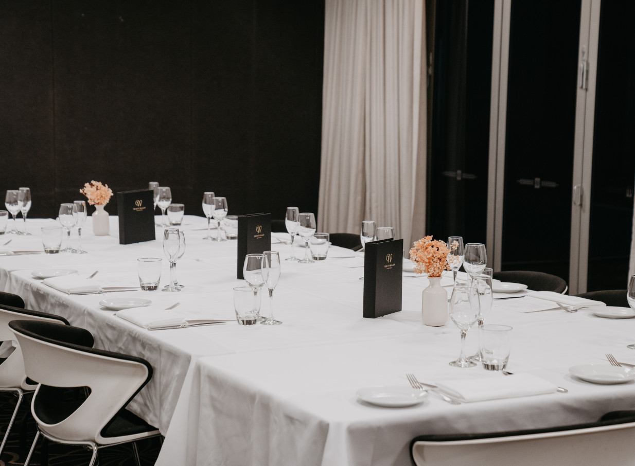 An elegant private dining setup at the over-water Trinity Wharf in Tauranga, featuring modern coastal decor.