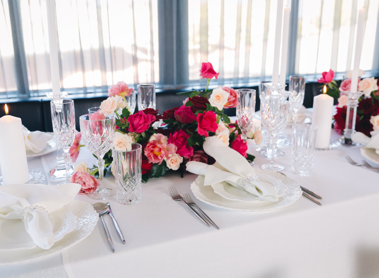 An elegant table setting with bright florals and candles in Karaka Pavilion, Auckland's sophisticated event venue.