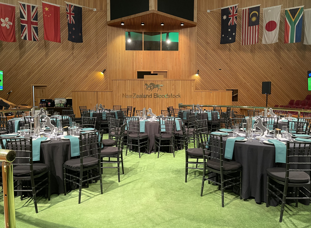 Karaka Pavilion, Auckland, is an event space with high wooden ceilings, set for an equine-themed banquet.