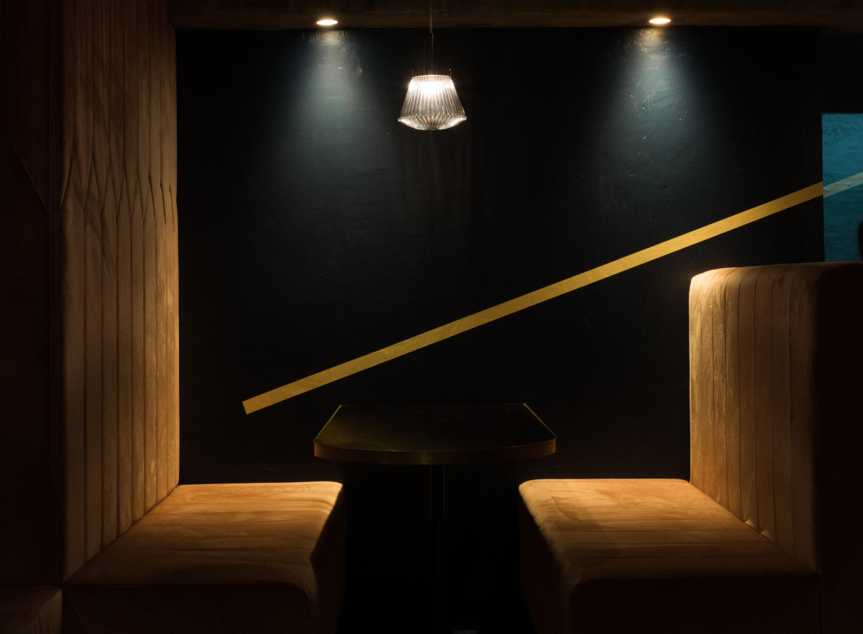 An intimate booth with plush seating and moody lighting at the modern, speakeasy-style Thursday Bar in Auckland.