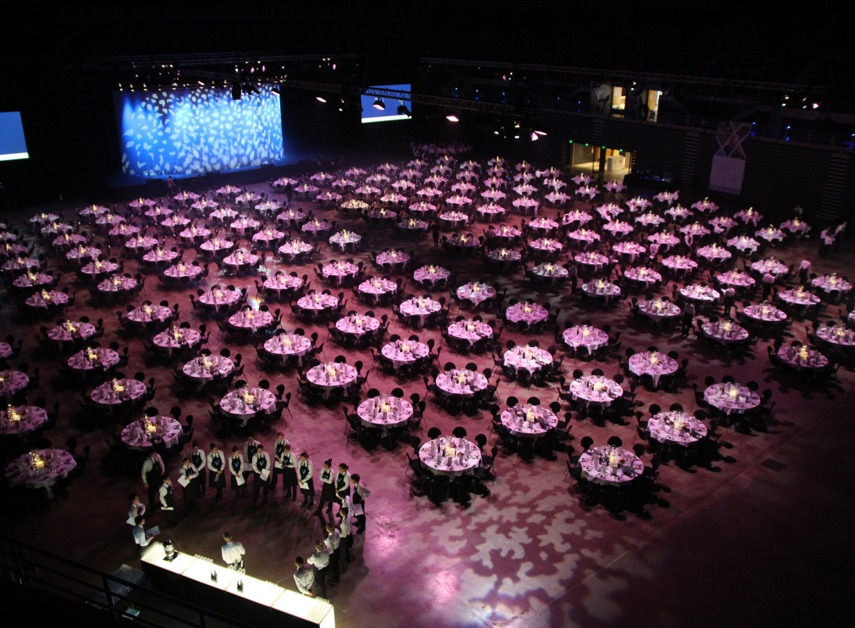 A vast gala dinner, with many pink-lit tables, fills the adaptable Wolfbrook Arena in Christchurch.